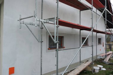 Hazırlanmadan önce asal kısımlarla kaplı bir duvarın yanında iskele. 