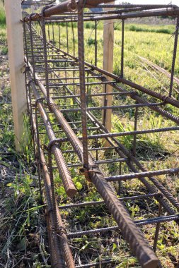 Çelik demirler, çelik teller, yeşil çimenler.