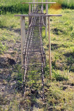 Çelik demirler, çelik teller, yeşil çimenler.