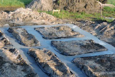 Suya karşı folyoyla izole edilmiş beton temeller, ahşap bir kazık ve iki vurucu tahta. 