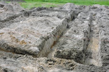 Yeni bir ev için beton döşeme, iki hamur tahtası ve bir kırmızı tuğla hattı için yapılan derin kazılar.