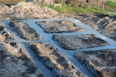 Suya karşı folyoyla izole edilmiş beton temeller, ahşap bir kazık ve iki vurucu tahta.