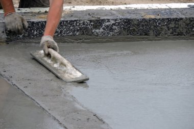 Islak betonu yüzdüren bir inşaat işçisi