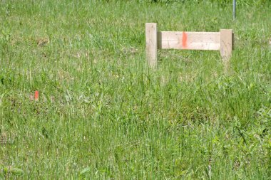 Yeni bir evin köşelerini işaretlemek için kullanılan tahta bir kazık ve bir binanın temelleri için bir siper.