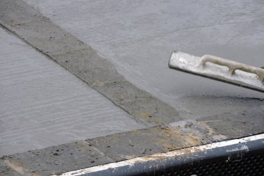 Islak betonu yüzdüren bir inşaat işçisi