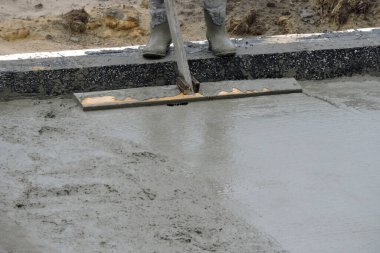  Islak betonu yüzdüren bir bina işçisi