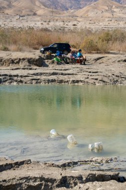 Ölü deniz, İsrail - 12 Şubat 2022: Kirlenmiş bir subatana yakın tatilciler, İsrail.