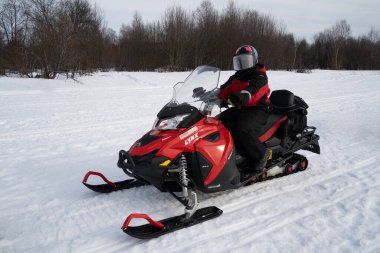 Rovaniemi, Finlandiya - 20 Mart 2022: Finlandiya 'da donmuş bir nehirde kar aracı turuna hazırlanan bir turist.