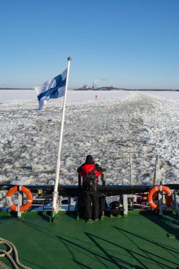 Rovaniemi, Finlandiya - 21 Mart 2022: Finniş buzkıranı Sampo 'nun kıç tarafındaki bir turist geride bıraktığı kırık buz izlerini fotoğraflıyor.