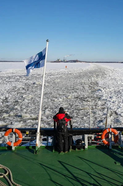 Rovaniemi, Finlandiya - 21 Mart 2022: Finniş buzkıranı Sampo 'nun kıç tarafındaki bir turist geride bıraktığı kırık buz izlerini fotoğraflıyor.