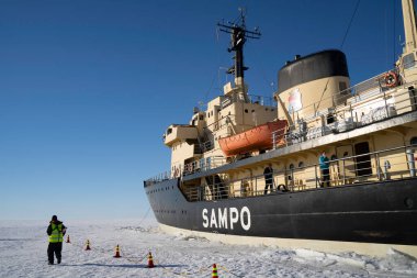 Rovaniemi, Finlandiya - 21 Mart 2022: Güneşli bir kış gününde donmuş baltık denizine demir atmış bir buzkıran gemisi Sampo.