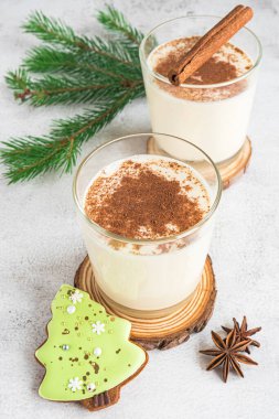 Gri arka planda iki bardak yumurta likörü.