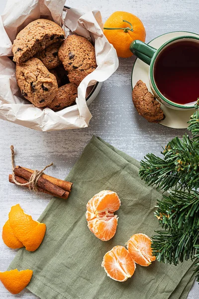 Uma tangerina descascada, biscoitos de chocolate e um ramo de abeto — Fotografia de Stock