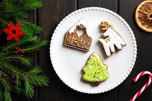 Biscoitos de Natal em uma chapa no fundo de madeira escuro — Fotografia de Stock