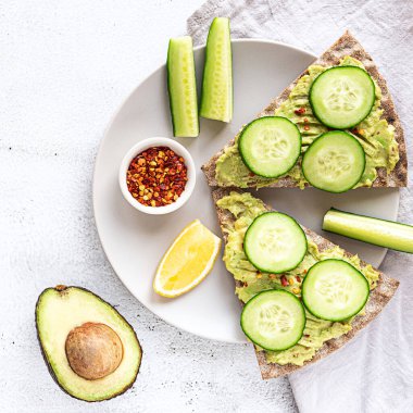 Avokado püresi ve salatalıklı çıtır ekmek sandviçleri.