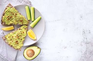 Avokado püresi ve salatalıklı çıtır ekmek sandviçleri.