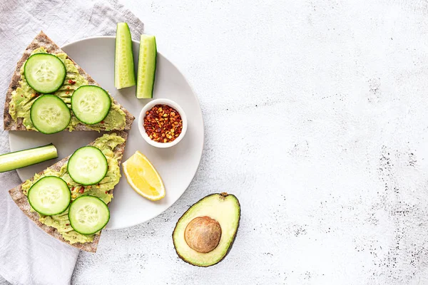 Knusprige Brotsandwiches mit pürierter Avocado und Gurke Stockfoto