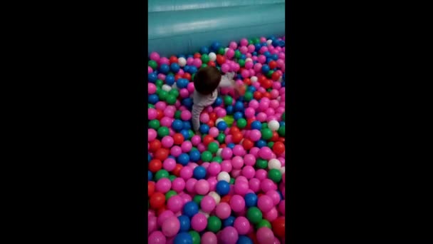 Een Kind Speelt Met Meerdere Gekleurde Ballen — Stockvideo