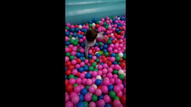 Niño Juega Con Varias Bolas Colores — Vídeo de stock