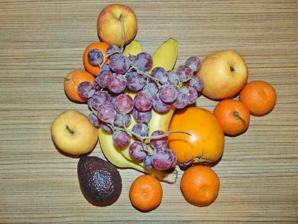 木の背景に果物 クレメンタイン リンゴ リンゴ バナナ アボカド ピンクのブドウ — ストック写真