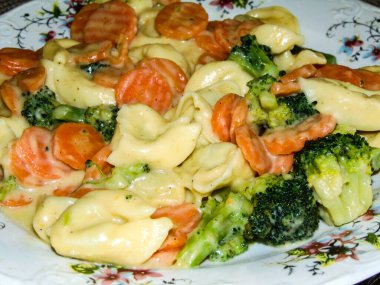 Peynirli Tortelloni makarna, ıspanak, ekşi krema, havuç ve brokoli.