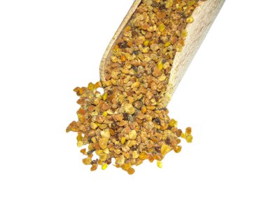 Tahta kaşıkta çiğ şekilsiz polen. Beyaz kaşıkta izole edilmiş.