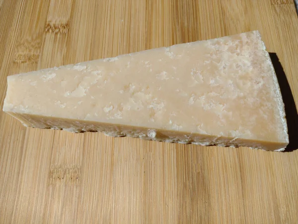 木製の背景にパルメザンチーズのスライス — ストック写真