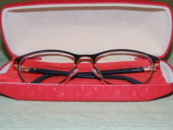 eyeglasses in a red case. Glasses case