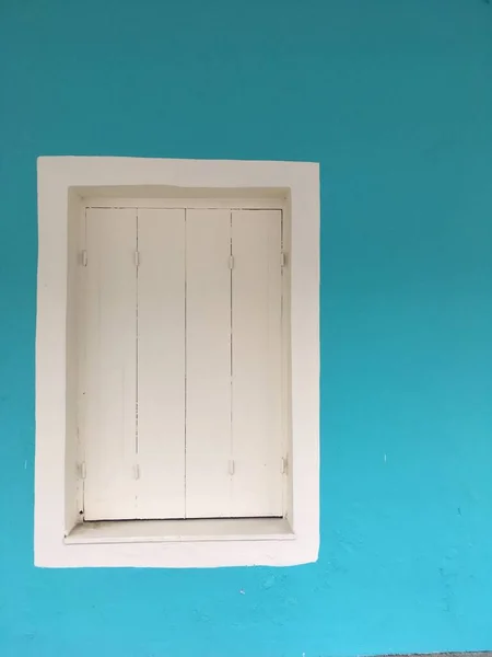 White shuttered window against a turquoise wall — Stock Photo, Image
