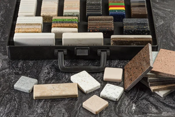 Large selection of stone samples for countertops and floors. Pieces of artificial acrylic stone in a sample box. A set of shades of countertops of different textures — Stock Photo, Image