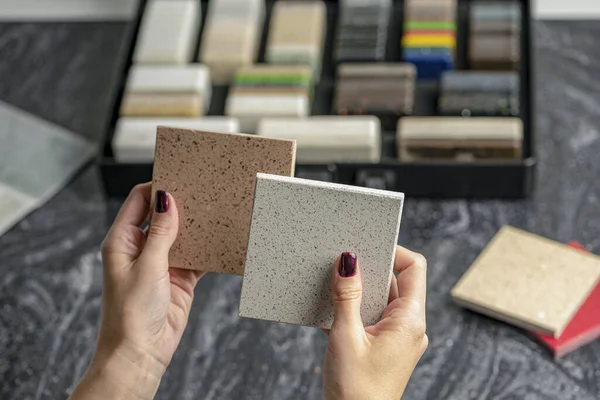 Samples of material for the countertop. Female hands are choosing interior elements for renovation. Samples of acrylic stone in hands. — Stock Photo, Image