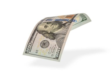 100 dolarlık banknot düşüyor. Döküm gölgesi, yarım katlanmış banknot beyaz arka planda.
