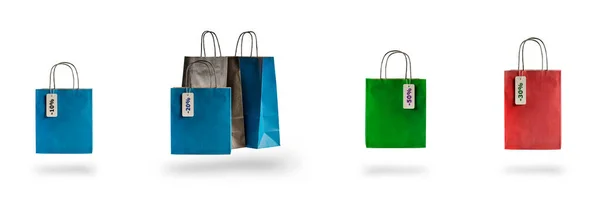 Conjunto de sacos de compras multicoloridos em um fundo isolado branco. Venda e descontos 10, 20, 30, 40, 50. Pacotes flutuam no ar, lançando uma sombra — Fotografia de Stock