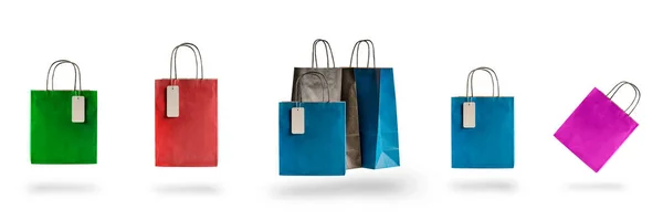 Conjunto de sacos de compras multicoloridos em um fundo isolado branco. Venda e descontos 10, 20, 30, 40, 50. Pacotes flutuam no ar, lançando uma sombra — Fotografia de Stock