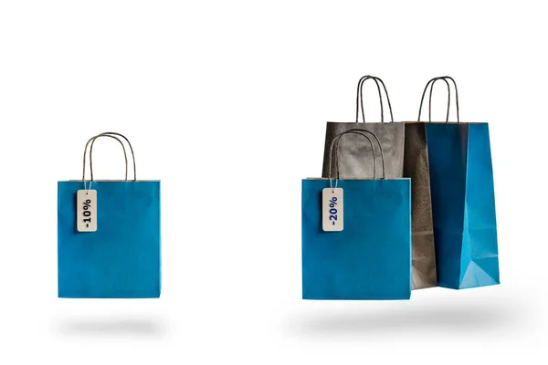 Nákupní papírové tašky různých barev na bílém izolovaném pozadí. Ceník slevy visící na prodej — Stock fotografie