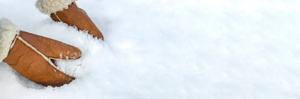Femme en mitaines de cuir roule une boule de neige à l'extérieur, gros plan. Les mains dans les mitaines chaudes font de la neige en hiver. mitaines en cuir marron dans la neige en hiver. — Photo