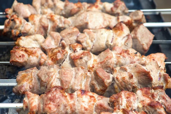 Churrasco de cozinha, churrasco de carne grelhada. Cozinhar shashlik de porco em espetos de metal. A fumaça das brasas se acumula sobre o prato. Banner publicitário com espaço de cópia — Fotografia de Stock