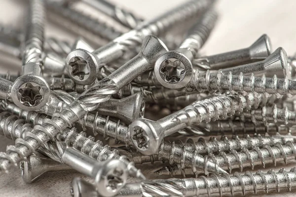 Close-up of universal silver screws with torx head. Self-tapping screws for wood, plywood or chipboard. Torx screws close up. — Stock Photo, Image