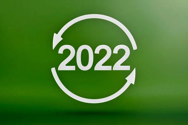 Ecologia, símbolo de reciclagem 2022, setas brancas formam um círculo. Imagem 3D sobre um fundo verde. Produtos verdes, energias renováveis verdes, gráfico que aponta para cima e para baixo — Fotografia de Stock