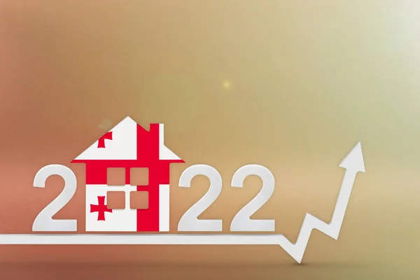 Az ingatlanköltségek Grúziában 2022-ben. Emelkedő építési költségek, biztosítás, bérleti díj Grúziában. Ház modell festett zászló színek, fel nyíl sárga háttér — Stock Fotó