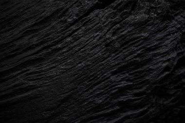 Texture of black old wood. Close-up of the texture of deep black bog oak. Sinuous wood texture with shadow