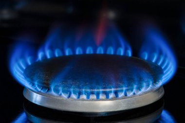 Doğal gaz yanması, propan. Siyah arka planda gaz sobası. Gaz mutfak sobasının mavi alevli bir parçası, yakın plan. Enerji krizi kavramı, doğalgazın fiyatı veya fiyatında artış