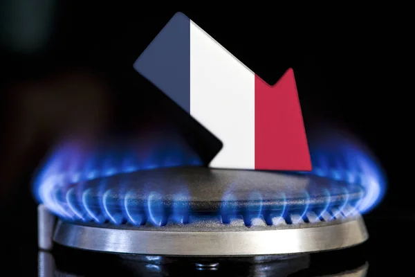 Decreased gas supplies in France. A gas stove with a burning flame and an arrow in the colors of the France flag pointing down. Concept of crisis in winter and lack of natural gas. Heating season