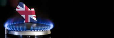 Decreased gas supplies in United Kingdom. A gas stove with a burning flame and an arrow in the colors of the United Kingdom flag pointing down. Concept of crisis in winter and lack of natural gas