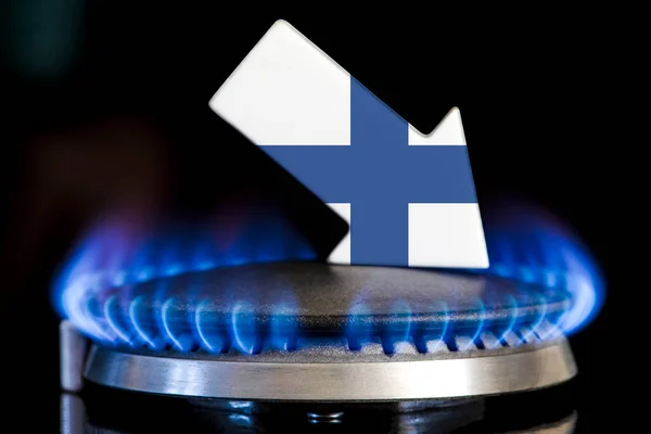 Decreased gas supplies in Finland. A gas stove with a burning flame and an arrow in the colors of the Finland flag pointing down. Concept of crisis in winter and lack of natural gas. Heating season
