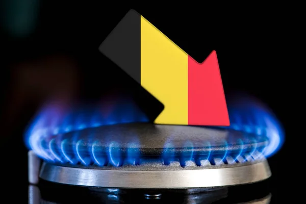 Decreased gas supplies in Belgium. A gas stove with a burning flame and an arrow in the colors of the Belgium flag pointing down. Concept of crisis in winter and lack of natural gas. Heating season