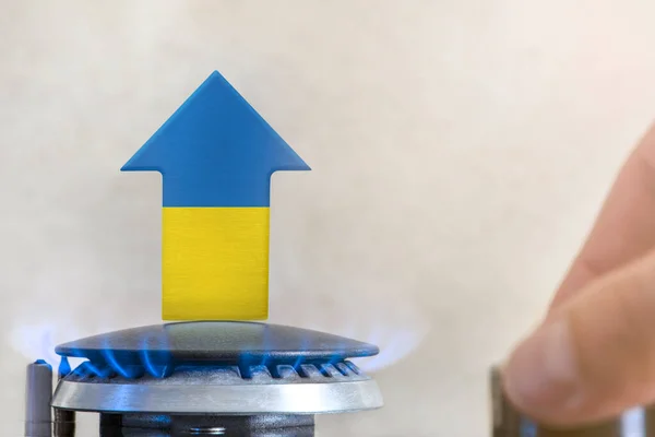 Gas price. Rise in gas prices in Ukraine. A burner with a flame and an arrow up, painted in the colors of the Ukraine flag. The concept of rising gas or energy prices