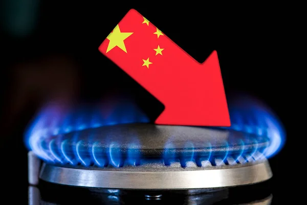 Decreased gas supplies in China. A gas stove with a burning flame and an arrow in the colors of the China flag pointing down. Concept of crisis in winter and lack of natural gas. Heating season