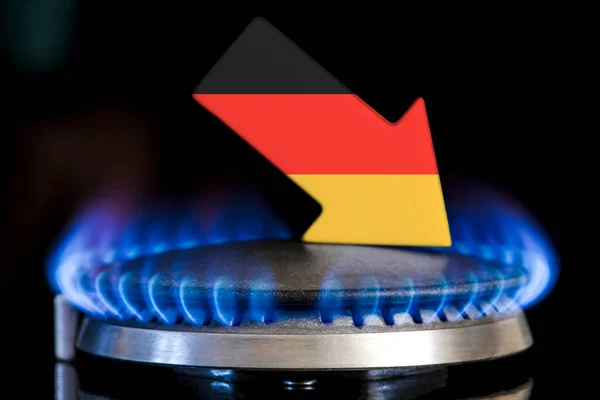 Decreased gas supplies in Germany. A gas stove with a burning flame and an arrow in the colors of the Germany flag pointing down. Concept of crisis in winter and lack of natural gas. Heating season