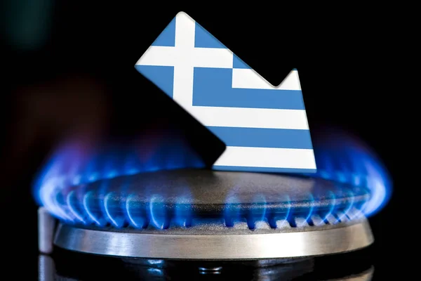 Decreased gas supplies in Greece. A gas stove with a burning flame and an arrow in the colors of the Greece flag pointing down. Concept of crisis in winter and lack of natural gas. Heating season
